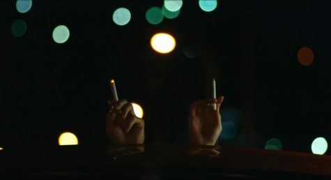 Actors Hidetoshi Nishijima (on the left) and Toko Miura (on the right) hold up cigarettes in solace in “Drive My Car”. Image courtesy of Certified Kino Bot.