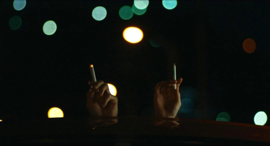 Actors Hidetoshi Nishijima (on the left) and Toko Miura (on the right) hold up cigarettes in solace in “Drive My Car”. Image courtesy of Certified Kino Bot.