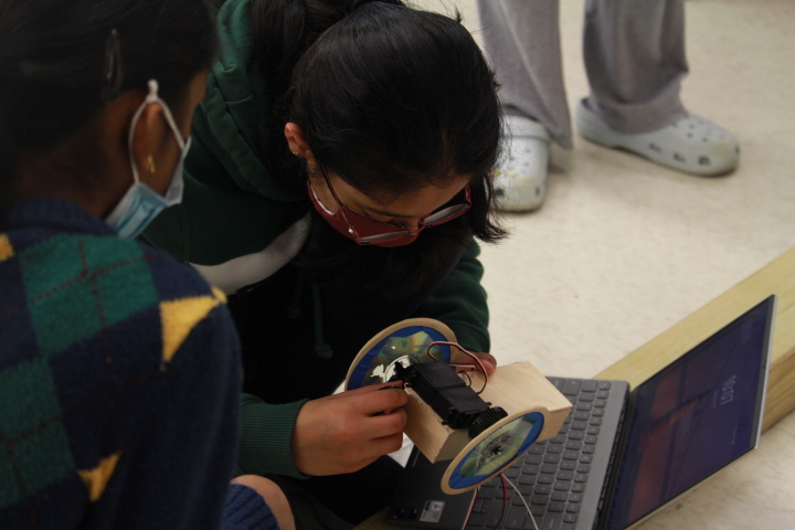 Freshman Samhitha Maramreddy studies her robot the day before the showcase, about to test it in the maze. 