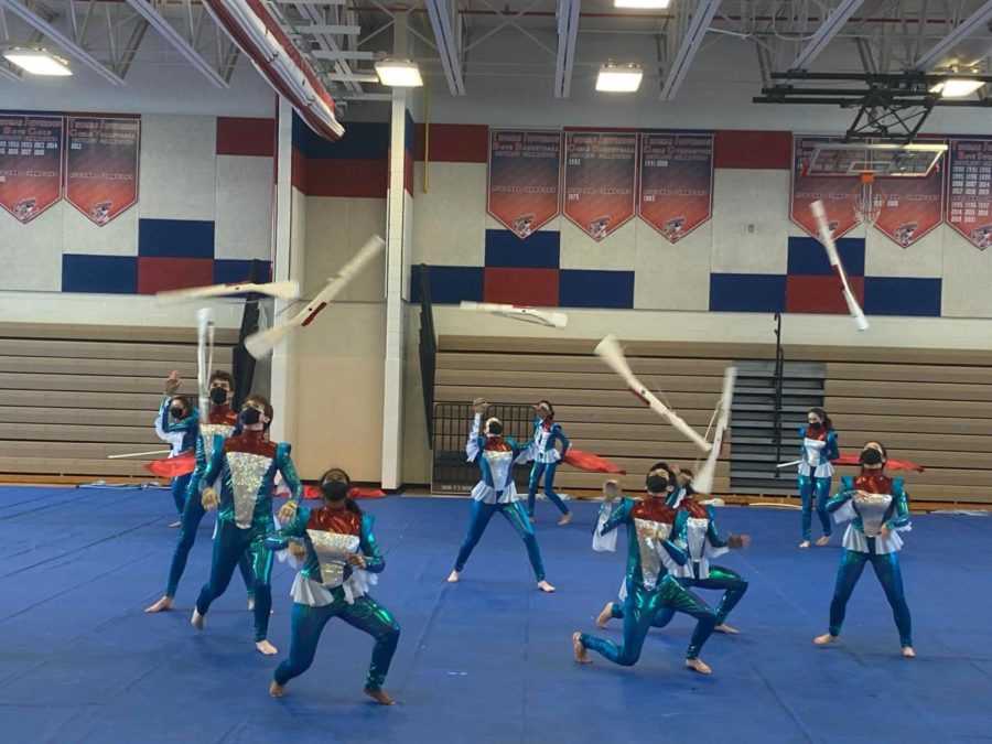 Color+guard+and+drum+line+students+perform+in+the+8th+period+on+March+18.+