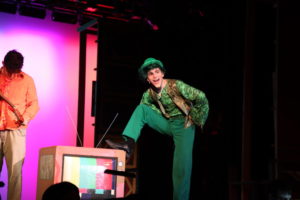 Mr. Wormwood, one of the antagonists of Matilda played by junior Gabriel Ascoli, grins at the audience. During part of the musical, Matilda puts bleach in Mr. Wormwood’s hair product, which turns his hair green, a gag which is difficult to pull off mid-scene. “[The] set [crew] built a sink with a big basin for him to stick his head into. There was a green wig that was set in that sink. While he stuck his head in the sink, its like 10 seconds or 15 seconds, he puts the wig on,” Abraham said. 