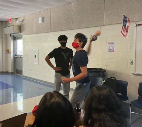 Freshman Deven Hagen throws a fake baby prop during his insult performance against freshman Rishi Roy during the final round of the tournament. 