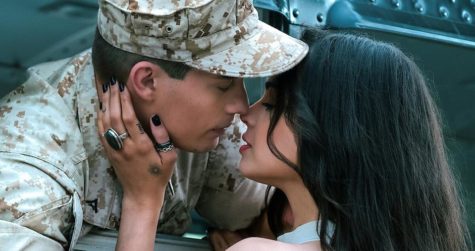 “Purple Hearts” characters, Cassie and Luke, say goodbye to each other before Luke is shipped out with the marines. The two characters are in a fake marriage to amass financial benefits. 