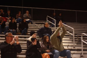 The audience cheers as the first touchdown of the game is made by the Colonials.