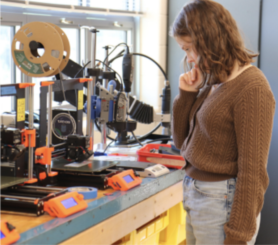 Senior Lauren Fisher 3D prints an object in the Robotics lab.