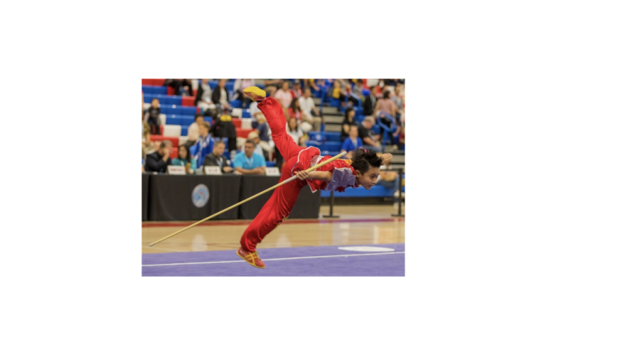 Kooc performs a skill with a wushu staff, known as a gunshu, during a competition in front of judges and an expectant crowd in 2019. Kooc has been participating in the sport since he was around two years old.