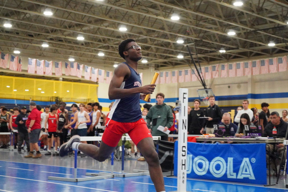 Pumping his arms for momentum, junior Steve Tchana races at an indoor track meet against Falls Church High School. “I like getting good times and improving and the team vibe,” Tchana said. “It’s really fun at practice, so that keeps me going.”