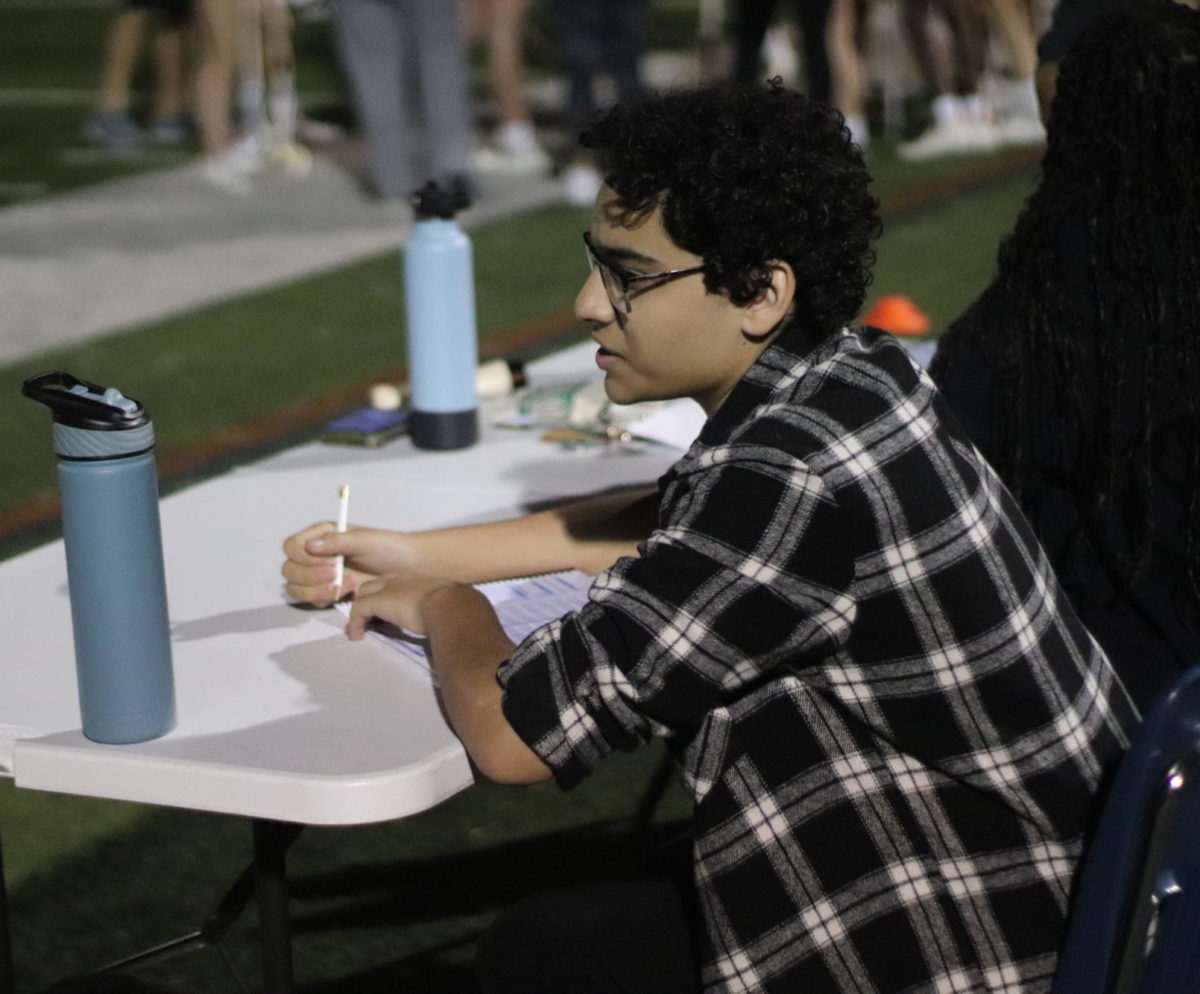 Elias works on keeping the scoresheet updated during a lacrosse game. “[My initial experience] was a bit tricky because I had to learn the ropes. I wasn’t very fluent in lacrosse at the time when I started because I wasn’t an athlete in that type of way. But in the end I learned the ins-and-outs of the sport. It took me going to the first couple games, asking the coaches questions, observing the referees call score, looking at the scoreboard, and working with friends.,” Elias said.