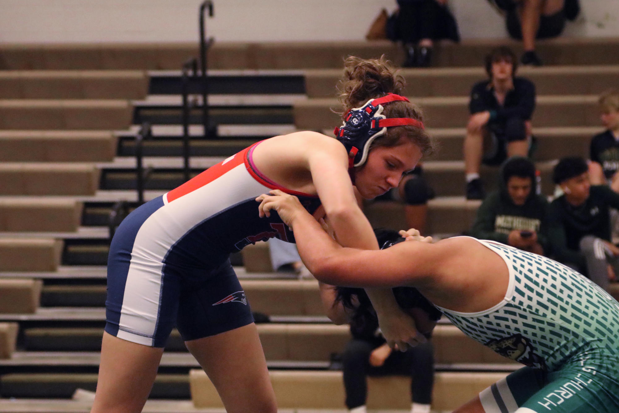 Freshman Jayelle Jones grapples with her opponent in a wrestling match against Falls Church. This is Jones’ first year participating in wrestling. “It’s the same mentality [when facing a guy or a girl]. Outside of the net, we’re friends, but on it, we’re not friends, and that’s the case with any gender on the mat,” Jones said.