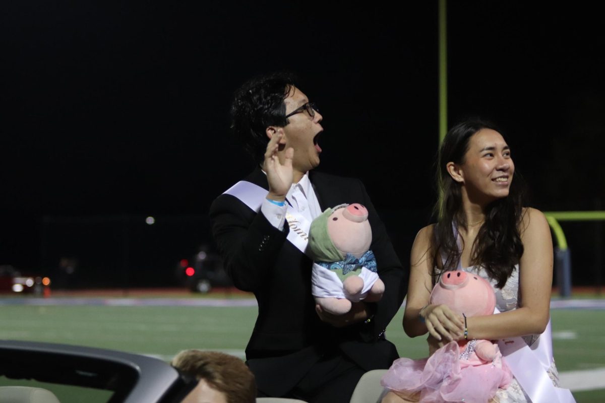 During halftime in the Homecoming football game, seniors Sonny Chen and Aurora Richard celebrate their Homecoming Court victory with the Hefty Hamburglars. “We hope the pigs spread happiness, serotonin, and dopamine,” Chen said.
