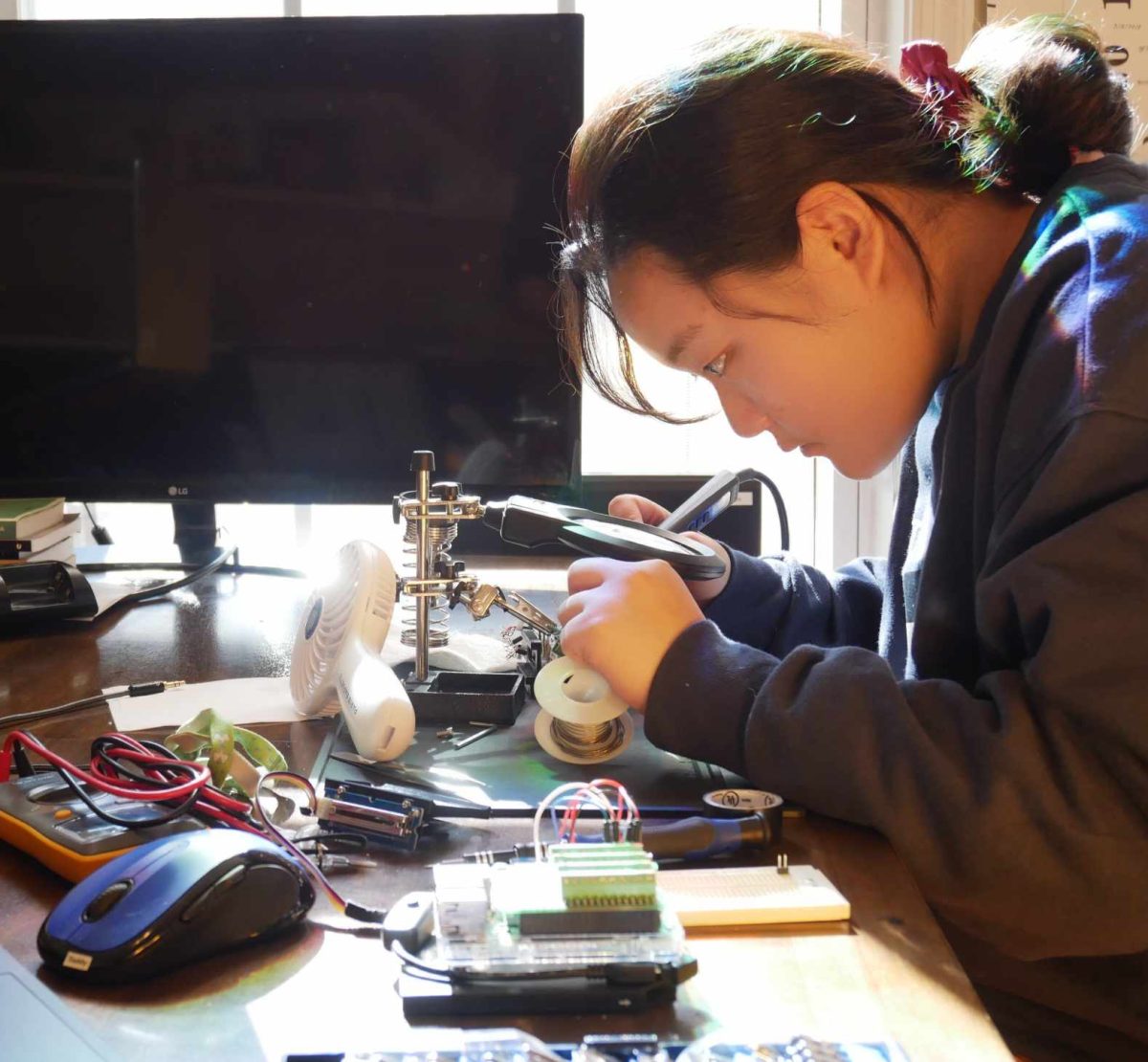 Senior Seoyoung Jun solders the board for her device as a part of her project. “I was like, 'What aids are there on the market that they use?' And I found that compared to [a lot of] other common [conditions], there wasn't much done for them,” Jun said. “It was a lot of the same technology that was used 30 years ago. So, I was like, 'I [should] try to develop something,' so I decided to develop a portable device. And then, I designed a little device that could help them recognize 3-D space.”
