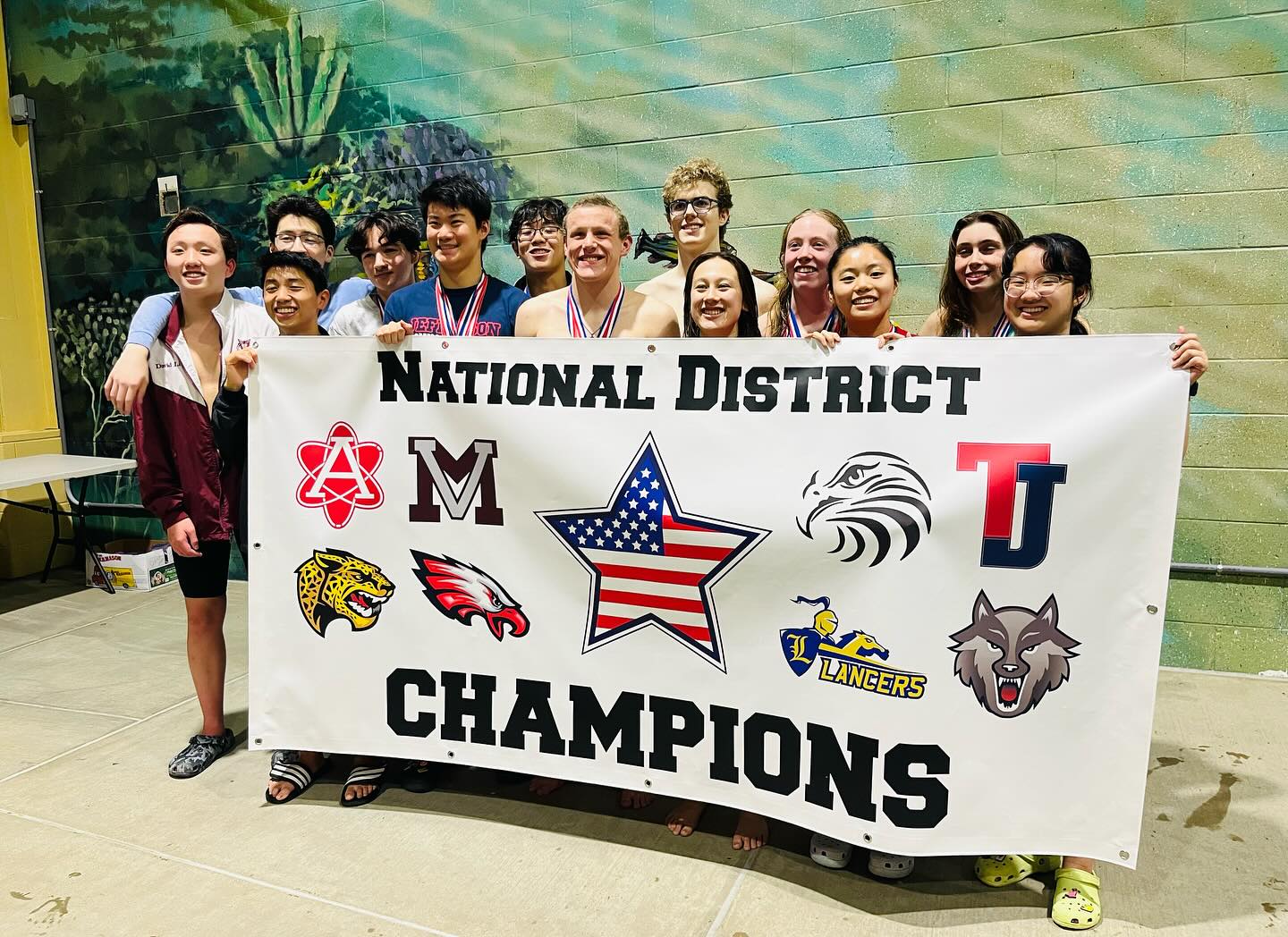 Securing the title as champions, the Jefferson Swim and Dive team poses with their National District Champions banner. “We were undefeated on the girls and guys side,” senior captain Paige Burke said. “I’m really proud of everyone.”