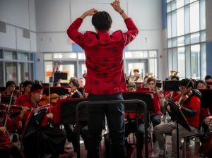 Kai Wang conducts Symphonic Orchestra as the first Jefferson orchestra performance composed and conducted by a student. Everyone in the ensemble dressed in red to symbolize good fortune and joy for the Lunar New Year. “I was just proud of him, because [the piece] was such quality,” orchestra director Allison Bailey said. 