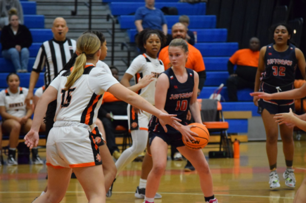 With a hard grip on the ball, junior Josie Clayton evades the defenders to get past and shoot the ball. “Unfortunately we lost, but I think we learned a lot and there were some memorable moments,” junior Helena Johnson said. 