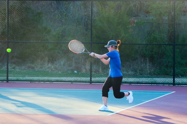During a scrimmage on March 12th against Oakton, Chance Nguyen backhands the tennis ball over the net during her singles game. 