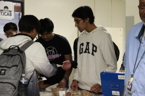 Handing out baked goods, junior Congressional debater Soham Jain serves customers alongside other speech and debate members. The bake sale was successful and was able to make over $200. “We got people to sign up and collectively sell the food,” junior Anirudh Chintaluri said.
