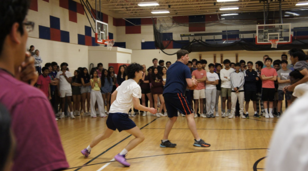 In one of the many preliminary rounds of the J-Day basketball tournament, two teams face off while students crowd around all four sides of the court. “We've always had a lot of people show up to the gym every lunch. They're kind of sacrificing their lunch to watch the game, but the turnout has been really good,” junior Andrew Wang said. 