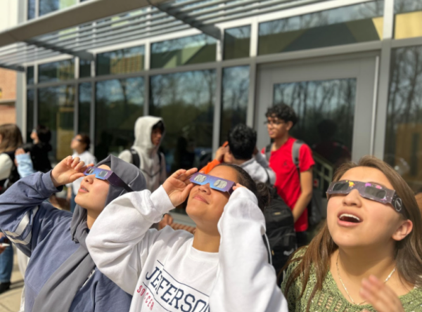 Using the provided solar eclipse glasses to protect their eyes, sophomores Saadia Anwaryan, Tori Isidro and Kimberly Cruz-Cruz look up at the eclipse. “I loved watching the eclipse because it reminds us that even when we’re everywhere in the world, we are some of the smallest bits that make up such a big universe,” Cruz-Cruz said. 