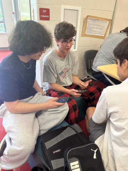 A group of juniors play “Clash Royale” on their phones during lunch. Lunch is the only time when phones are allowed to be out. “I think once we adapt to it, it's not going to be something we miss because [for] everyone moving forward, that'll have been the policy [since] middle school,” DNA science and biology teacher Aubrie Holman said. 
