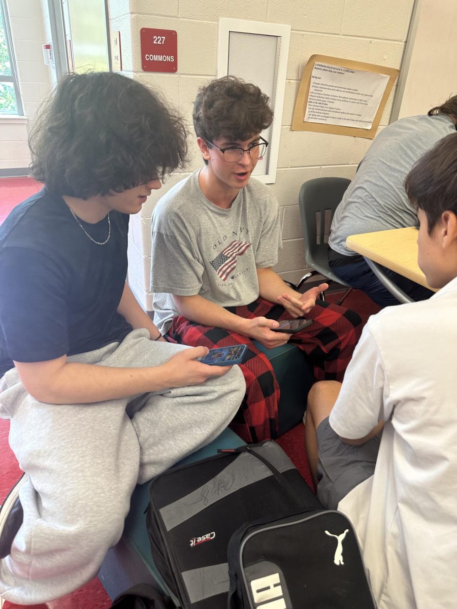 A group of juniors play “Clash Royale” on their phones during lunch. Lunch is the only time when phones are allowed to be out. “I think once we adapt to it, it's not going to be something we miss because [for] everyone moving forward, that'll have been the policy [since] middle school,” DNA science and biology teacher Aubrie Holman said. 
