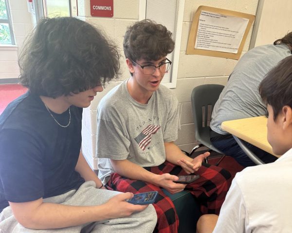A group of juniors play “Clash Royale” on their phones during lunch. Lunch is the only time when phones are allowed to be out. “I think once we adapt to it, it's not going to be something we miss because [for] everyone moving forward, that'll have been the policy [since] middle school,” DNA science and biology teacher Aubrie Holman said. 
