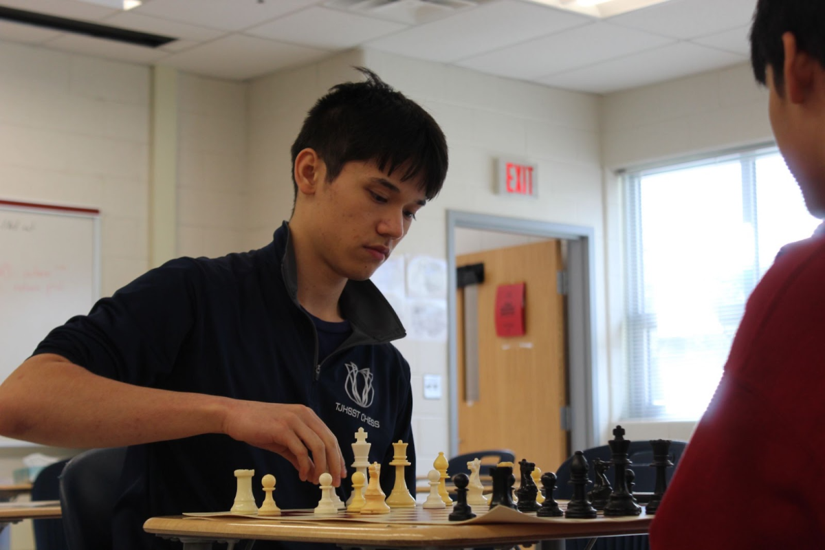Kent Slate picks up a chess piece in a game during lunch. “I've been playing for so long,” freshman Vivaan Khambhati said. “I enjoy playing with friends as well. I think it's just a fun game to play.”