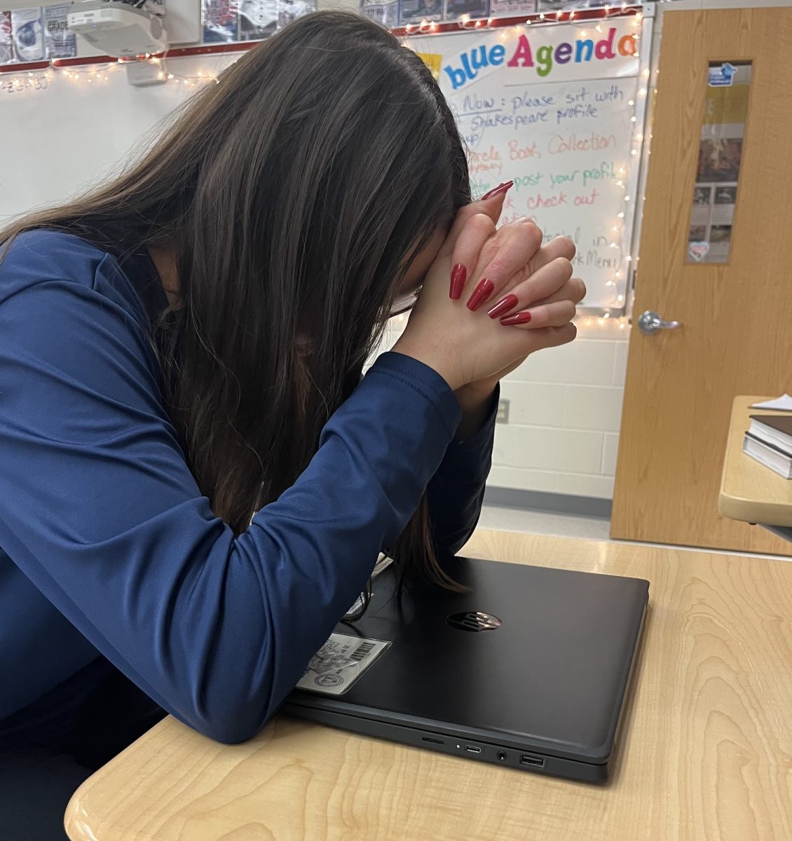 Senior Julia Baer sits over her computer, defeated by the workload. “[Senior year] is better than junior year, but I’m excited for it to be over,” Baer said. 

