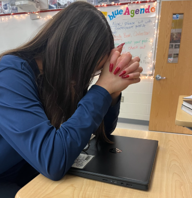 Senior Julia Baer sits over her computer, defeated by the workload. Often during senior year, students bear the challenge of normal schoolwork and college applications.  “[Senior year] is better than junior year, but I’m excited for it to be over,” Baer said. 
