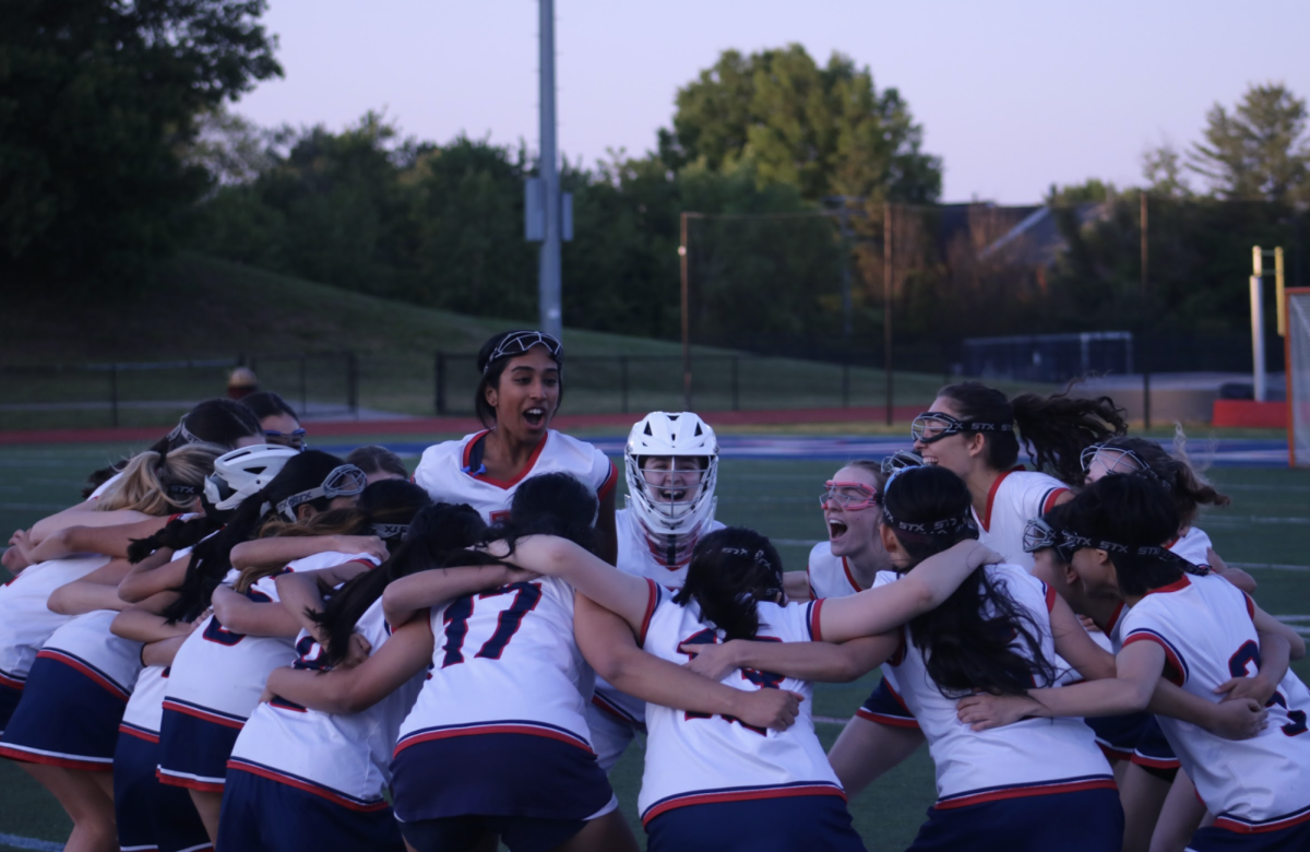 Leading the team in a pre-game cheer, senior Lakshitha Balachandar prepares the colonials for their Senior Night game against Annandale High School on May 7.