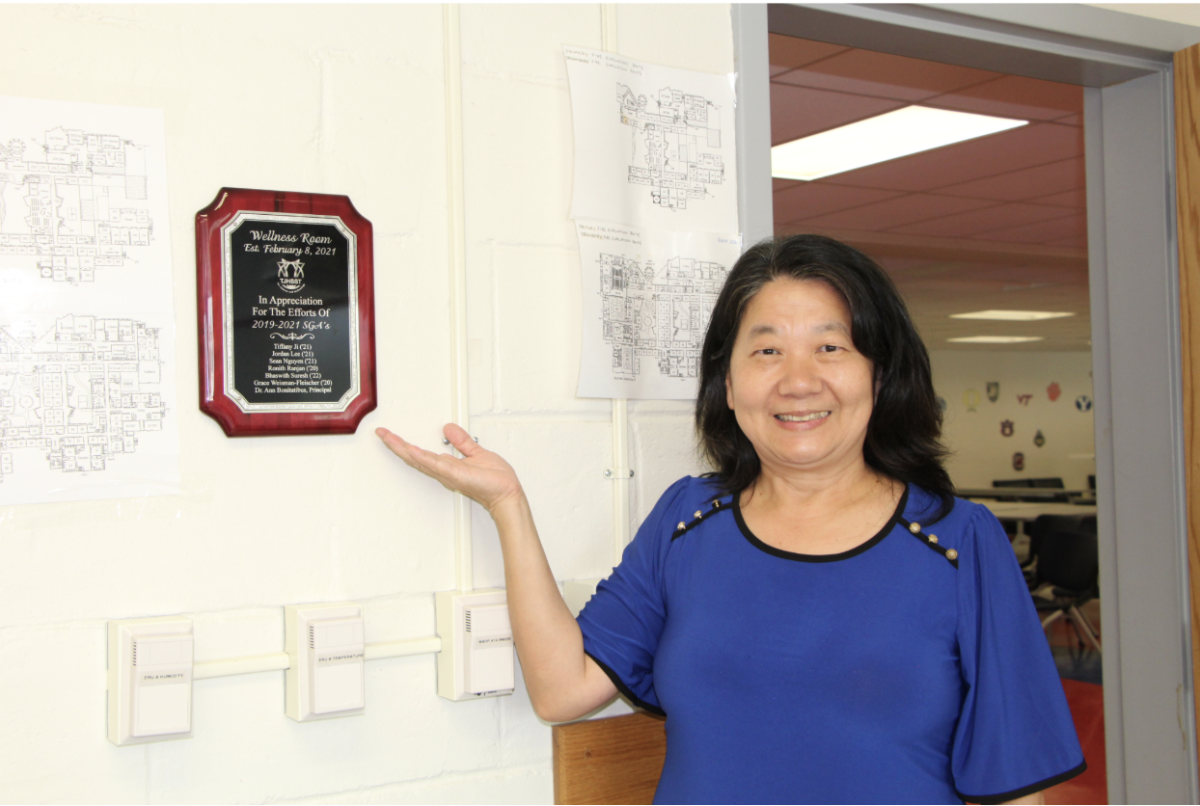Wellness room supervisor Lee-Lin Finkbeiner points towards the sign that indicates when the room was established. “SGA got a [TJ Partnership fund], and the students designed this room,” Finkbeiner said. “I make sure the kids are safe and doing okay.”